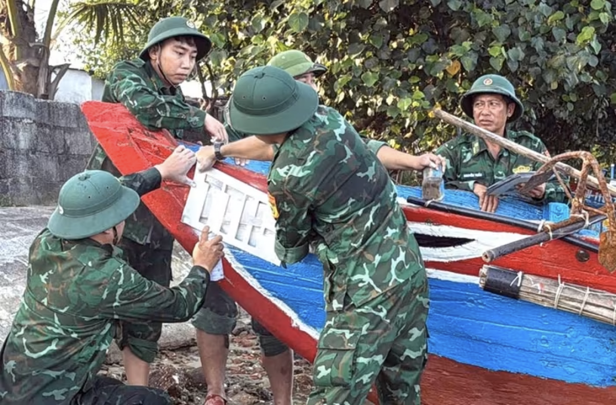 Lực lượng Đồn biên phòng cảng Chân Mây hỗ trợ ngư dân sơn biển số lên tàu cá