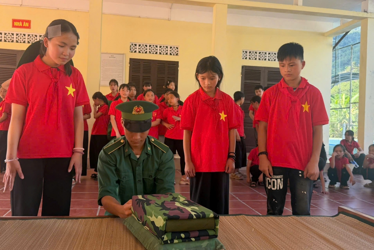 Chiến sĩ biên phòng hướng dẫn học sinh cách gấp nội vụ trong quân đội (Ảnh: BP Tuyên Quang)
 