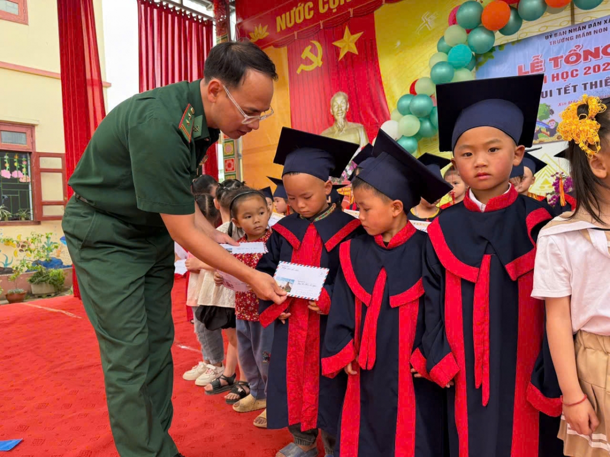 Trung tá Nguyễn Ngọc Huân, Chính trị viên phó Đồn BPCK Xín Mần trao quà cho các em nhỏ
(Ảnh: ĐVCC)
