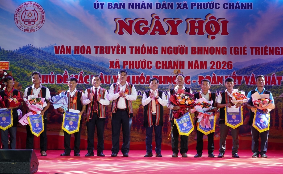 Giám đốc Sở Dân tộc và Tôn giáo Nguyễn Mạnh Hà (thứ 5 từ trái qua) cùng lãnh đạo xã Phước Chánh tặng cờ lưu niệm cho đại diện 7 thôn tham gia ngày hội.