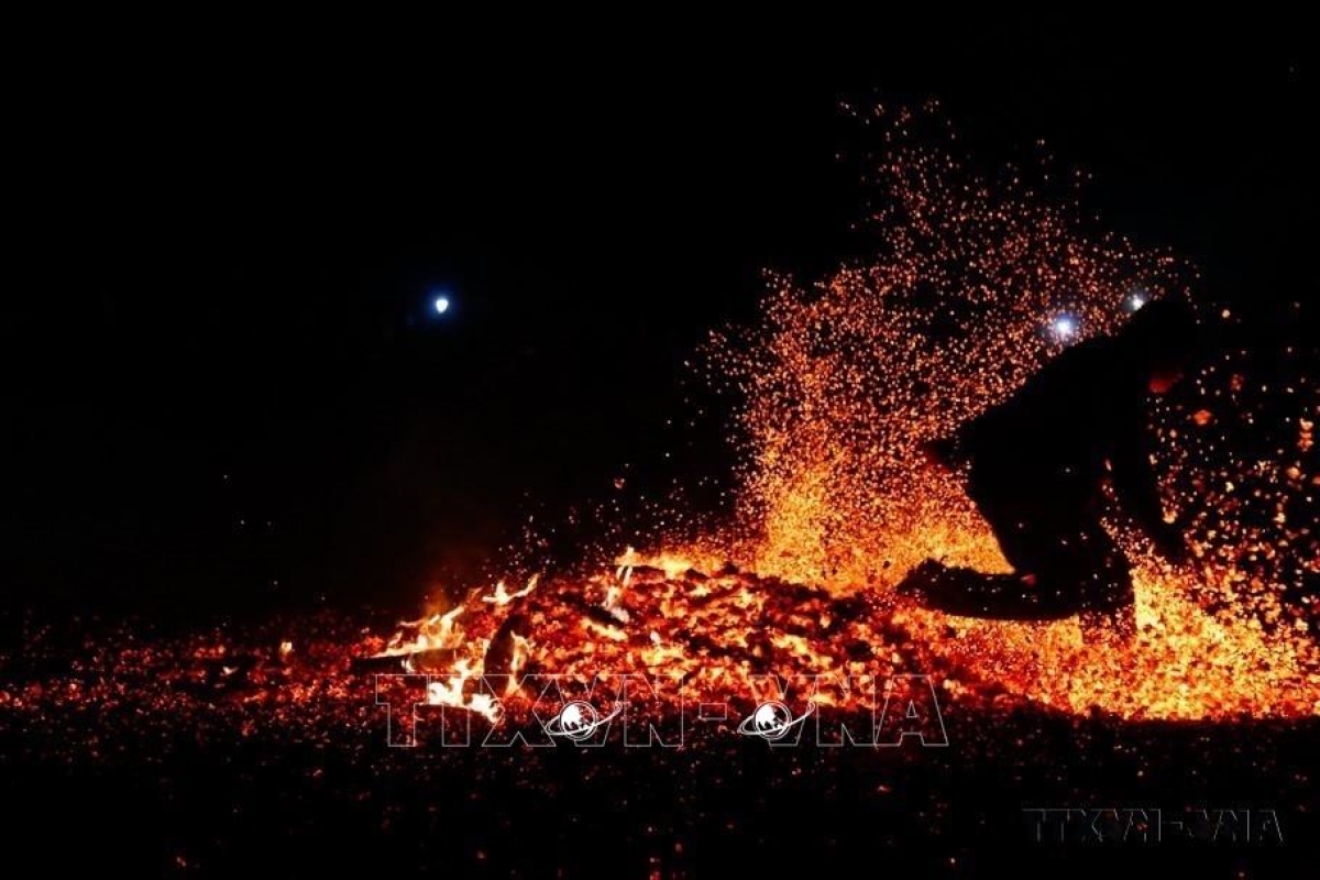 Theo tiếng Pà Thẻn, hội nhảy lửa được gọi là “Po dinh họn a tờ.” Ngày nay, lễ hội này được biết đến rộng rãi với tên gọi Lễ hội nhảy lửa của người Pà Thẻn, nhằm tạ ơn trời đất, thần linh đã cho một mùa vụ tươi tốt và cũng cầu chúc cho một vụ mùa năm sau, đống lửa sẽ mang lại sự ấm áp, may mắn xua đi cái khắc nghiệt của mùa đông đang tới. Trong ảnh: Sau khi được thầy cúng làm lễ, người thanh niên nhảy bật lên bằng cả hai chân và lao vào giữa đống lửa cháy rừng rực mà không bị bỏng - Ảnh: Nam Sương/TTXVN.