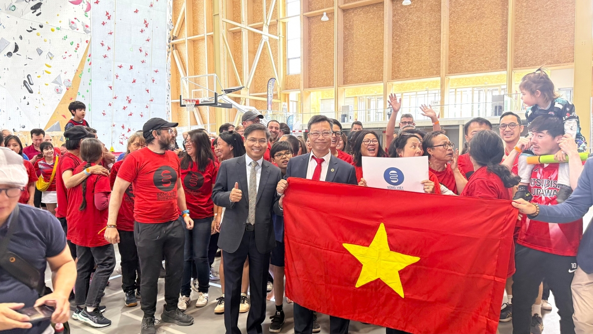 Đại diện các hội đoàn, tổ chức và cộng đồng người Việt tại Pháp tự hào bên lá quốc kỳ Việt Nam. Ảnh: Anh Tuyển
