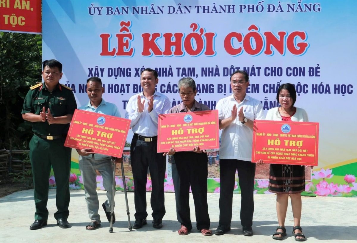 Phó Chủ tịch UBND thành phố Trần Anh Tuấn (thứ 2 từ phải sang) cùng lãnh đạo xã Sông Kôn trao bảng hỗ trợ nhà ở cho hộ con đẻ người hoạt động kháng chiến ở xã Sông Kôn. Ảnh: VA RA