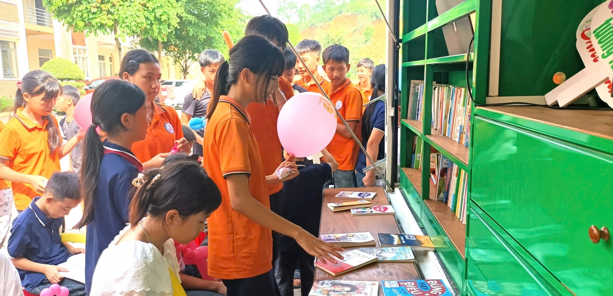 Các em thiếu nhi vùng biên giới háo hức trước tủ sách mới - Ảnh: Quang Thảo.