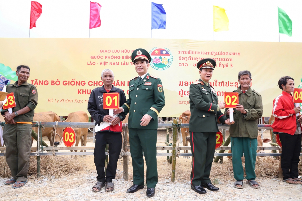 Hai Bộ trưởng Bộ Quốc phòng trao cặp bò giống cho các hộ dân nghèo tại Lào (Ảnh: Khánh Toàn)