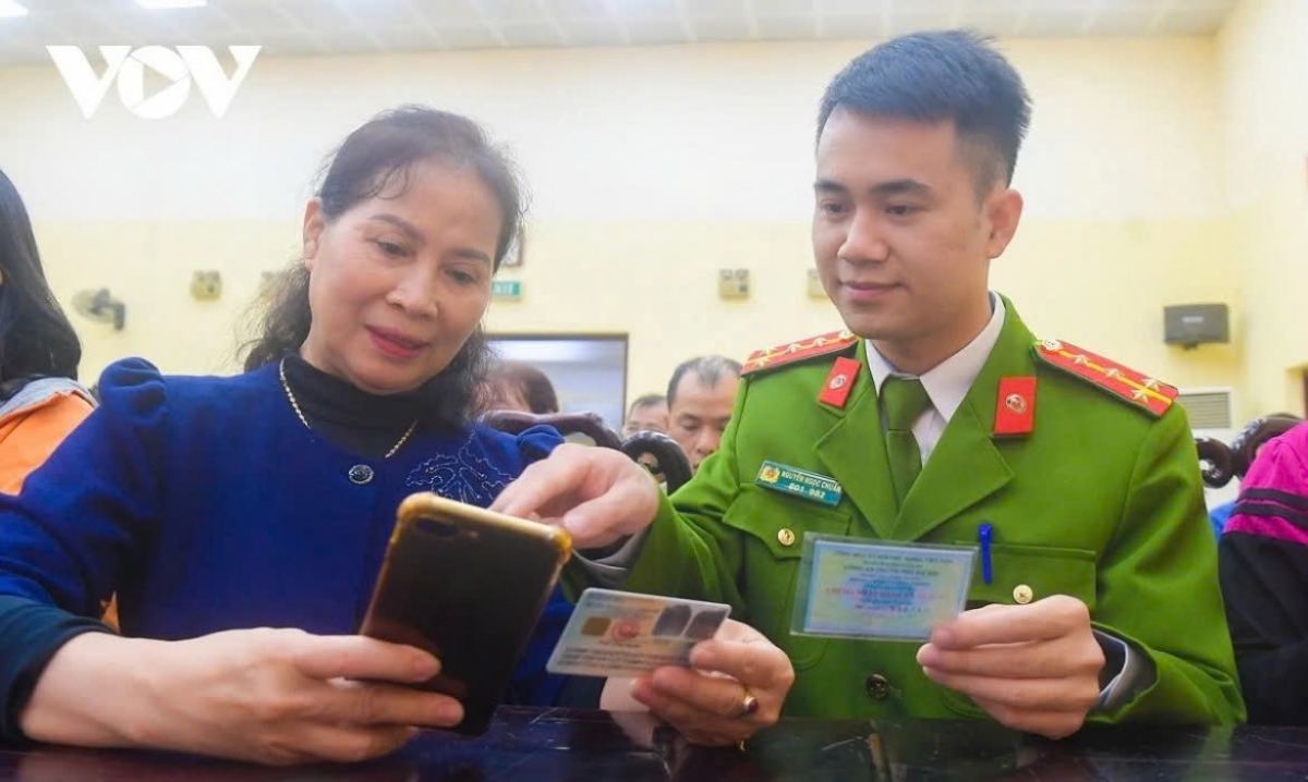 Lực lượng chức năng hỗ trợ người dân sử dụng VNeID. (Ảnh: Trọng Phú)