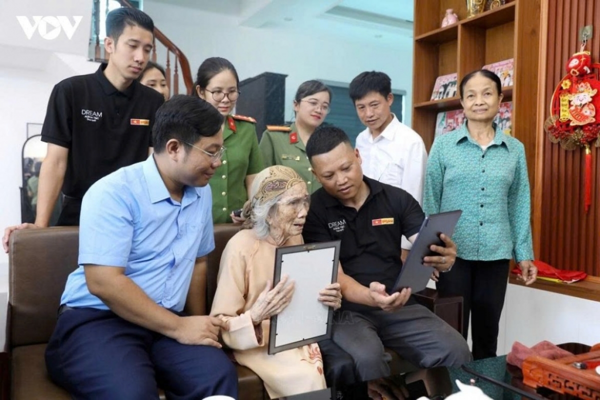 Thân nhân gia đình liệt sĩ Hoàng Đình Nhiệm thôn Cù Tu, xã Xuân Trúc, tỉnh Hưng Yên xúc động nhìn ảnh liệt sĩ được phục dựng.