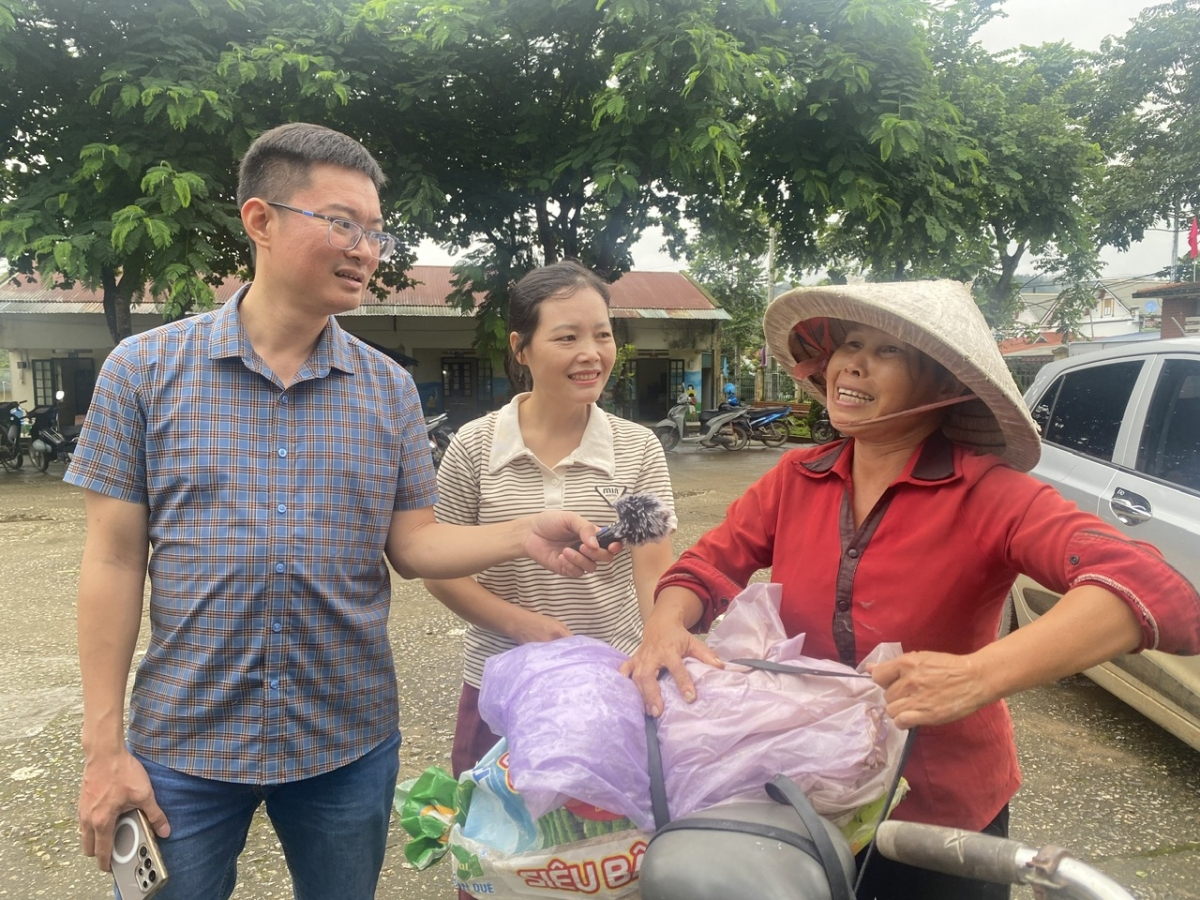 Bà Đặng Thị Hạnh (áo đỏ) lóc cóc đạp xe, chở theo yến gạo mới xát và mấy quả bí đỏ hái sau vườn đến điểm tiếp nhận ủng hộ đồng bào Mường Than (Ảnh: Khắc Kiên)