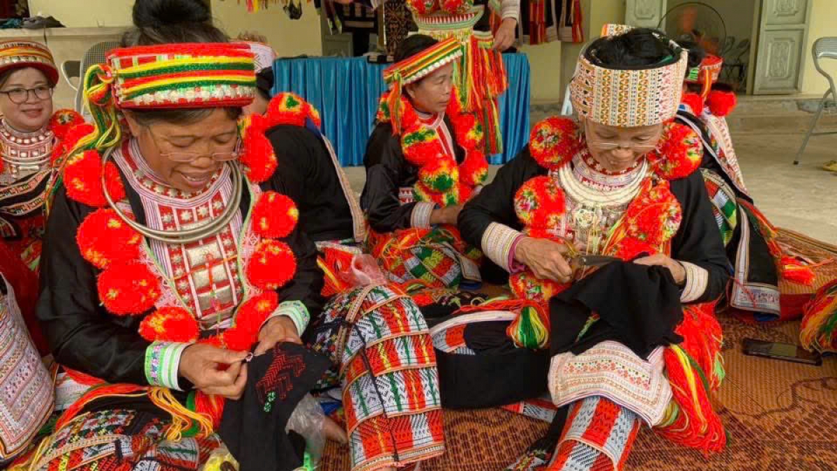 Bà Triệu Thị Coi (bên phải ảnh) vẫn tỉ mẩn cùng những đường kim, mũi chỉ - Ảnh: Công Luận