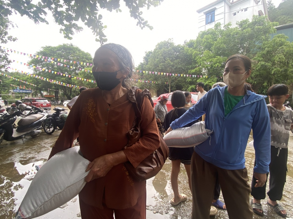 Nhiều người cao tuổi vẫn tự tay bê những bao gạo nghĩa tình đến điểm tập kết cứu trợ lũ lụt (Ảnh: Khắc Kiên)