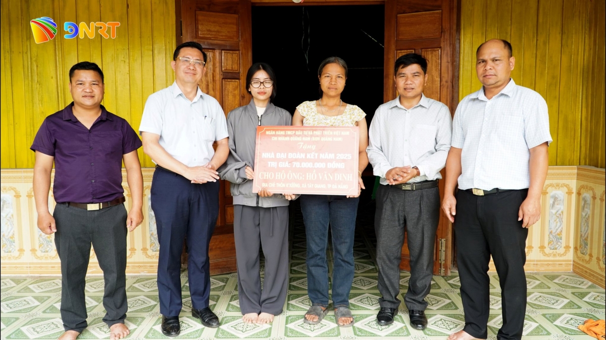 Đại diện lãnh đạo xã Tây Giang trao bảng tượng trưng hỗ trợ cho hộ ông Hồ Văn Dinh. Ảnh: B.BỨC
