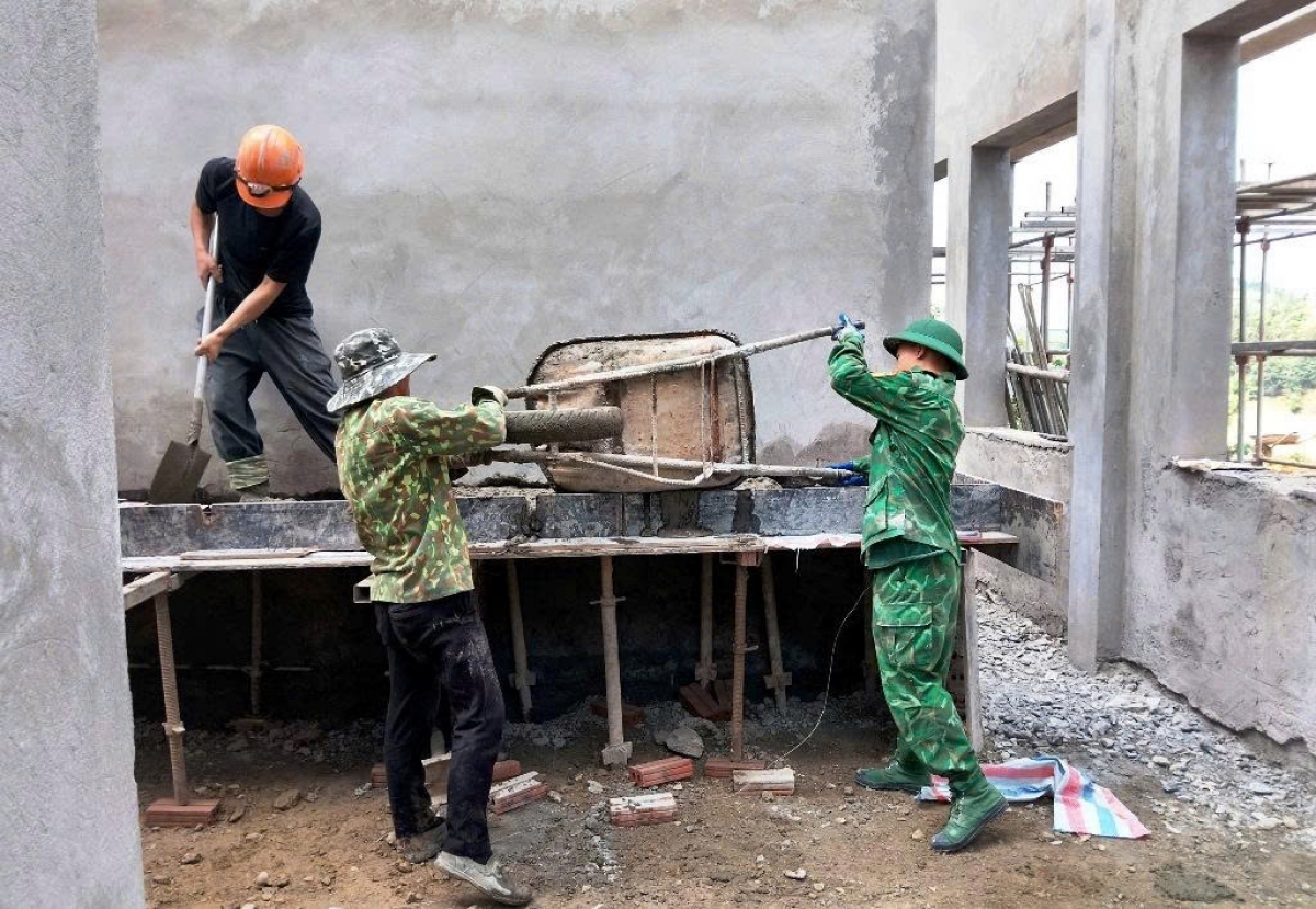 Bộ đội Biên phòng vận chuyển vữa trát tường (Ảnh: Duy Cường)