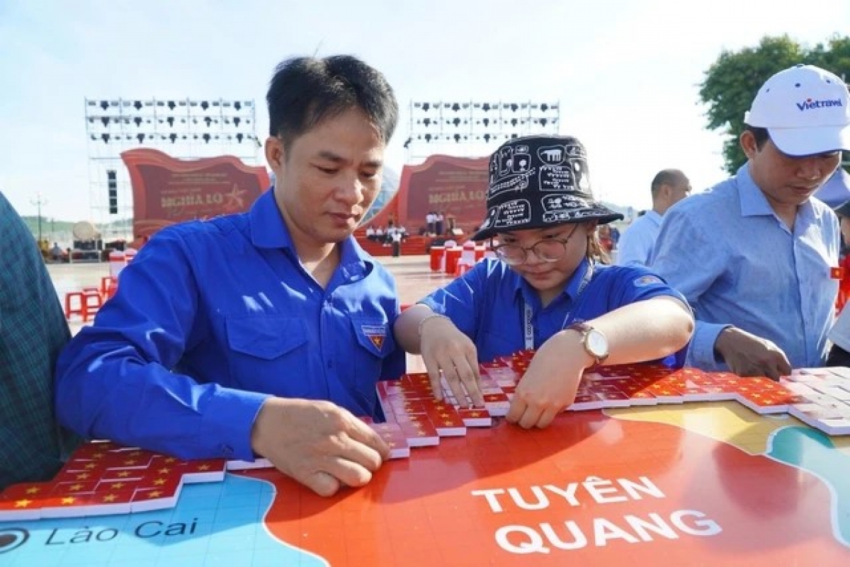 Đoàn viên, thanh niên tham gia lắp ghép mô hình bản đồ Việt Nam bằng những lá cờ