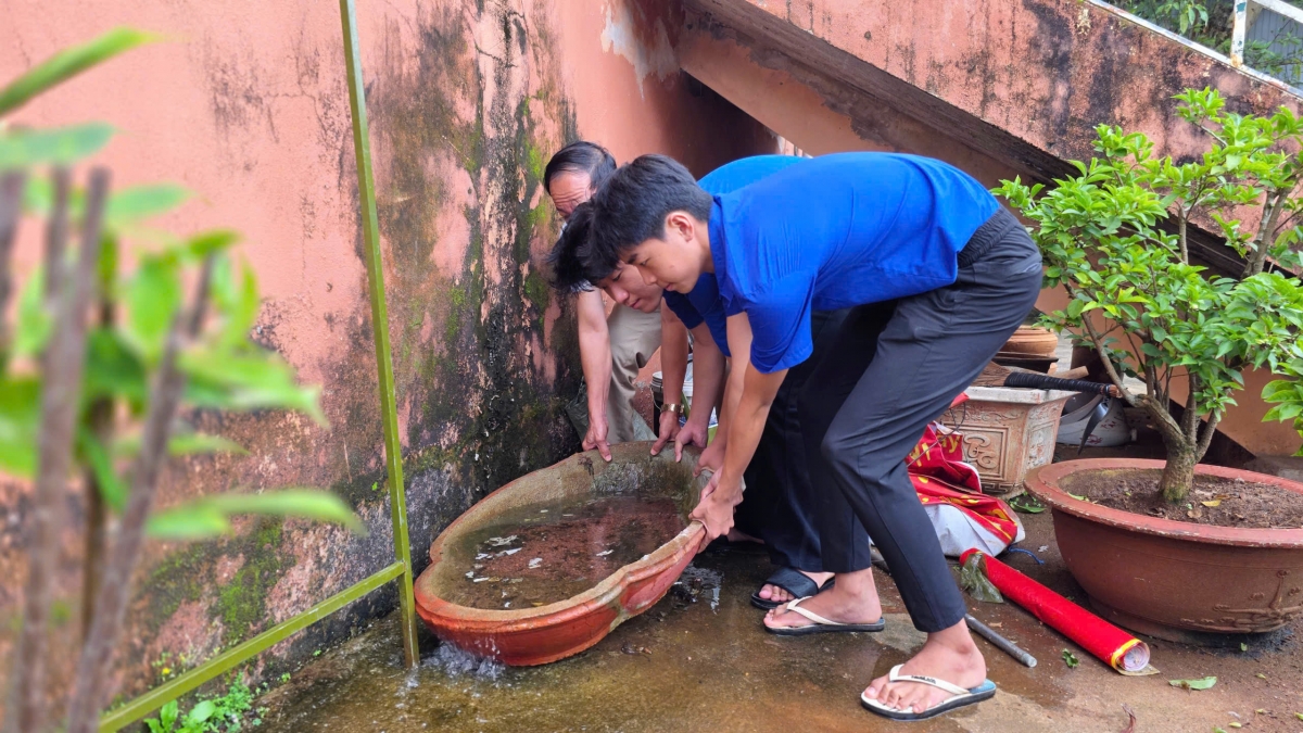 Đổ nước ra khỏi những vật dụng chứa nước ngoài trời. Ảnh: Hoàng Qui/VOV-Tây Nguyên