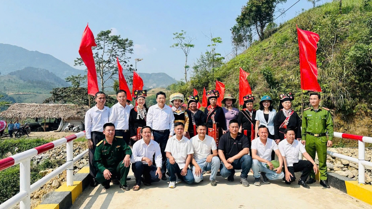 Lãnh đạo địa phương chụp ảnh cùng nhóm thiện nguyên và bà con vùng cao trên cây cầu mới. Ảnh: Đinh Tuấn/VOV Tây Bắc