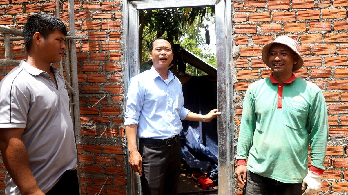 Ông Y Ung Byă (bìa phải) phấn khởi khi ngôi nhà mơ ước đang dần hoàn thiện. Ảnh: H Xíu.