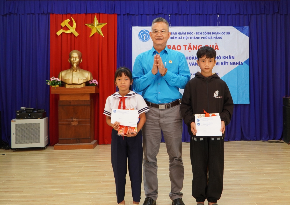 Ông Nguyễn Hùng Anh, Phó Giám đốc Bảo hiểm xã hội trao quà tặng học sinh đồng bào Cơ Tu ở xã Sông Vàng. Ảnh: Lê Tuyết
