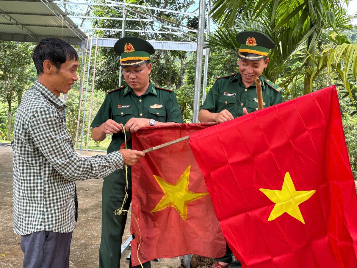 Bộ đội biên phòng đến từng nhà giúp dân thay mới lá cờ Tổ quốc (Ảnh: CTV Thiên Bình)