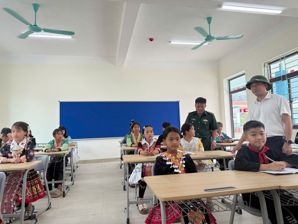 Cán bộ biên phòng cùng các lực lượng trực tiếp đưa các em học sinh vào những phòng học mới tại trường liên cấp nội trú biên giới. Ảnh: Hải Thượng.
