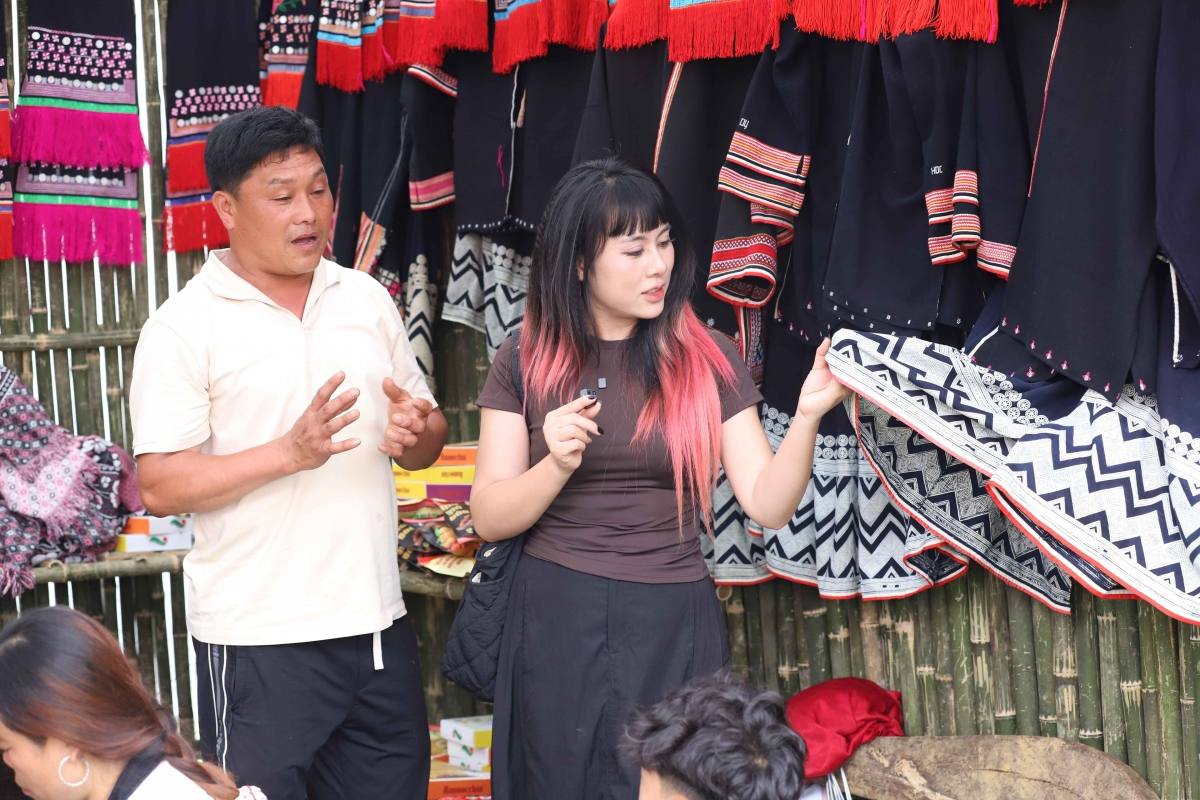 Du khách hào hứng với những trang phục thổ cẩm, được dệt thủ công từ những đôi bàn tay khéo léo của người dệt vùng cao. Ảnh: Trấn Long