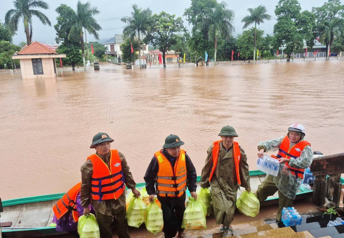 Các lực lượng đưa cơm, nước uống hỗ trợ bà con vùng ngập lụt. Ảnh: Thanh Hiếu