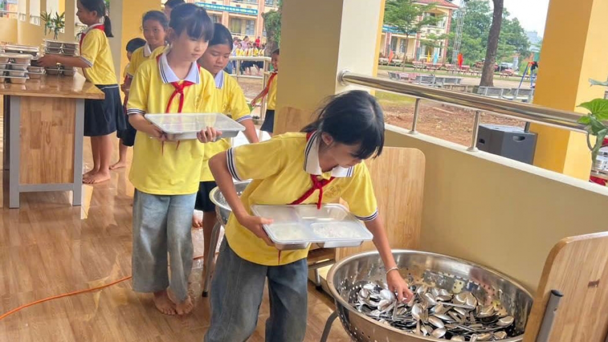 Học sinh được hướng dẫn xếp hàng để lấy thức ăn và muỗng (Ảnh: Thiên Lý)