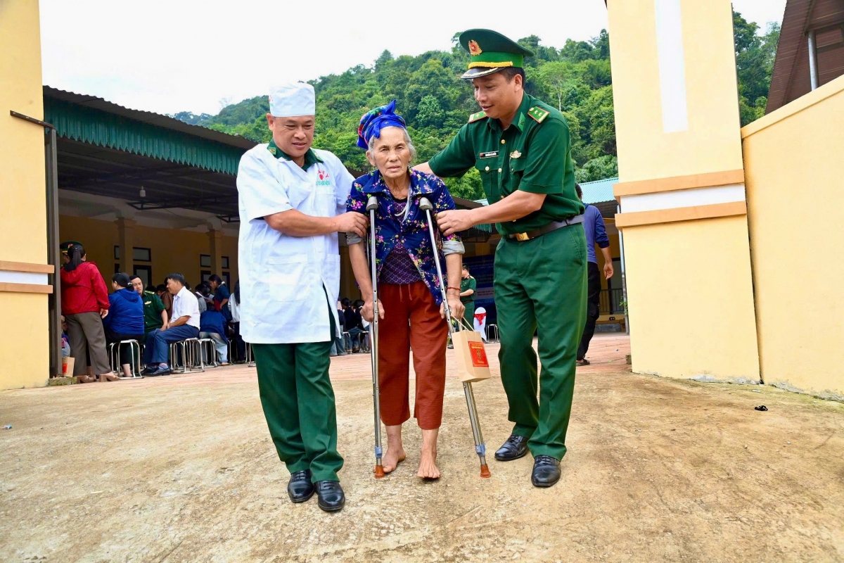 Quân y đồn biên phòng Na Ngoi hỗ trợ đưa người cao tuổi đến điểm khám bệnh (Ảnh: Trần Lê Thạch)