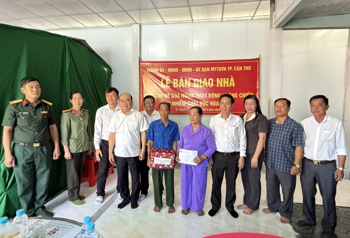 Lãnh đạo thành phố Cần Thơ và xã Vị Thanh 1 tặng quà và chụp hình lưu niệm cùng cha mẹ chị Phạm Thị Út Hương. (Ảnh: Tấn Phong)