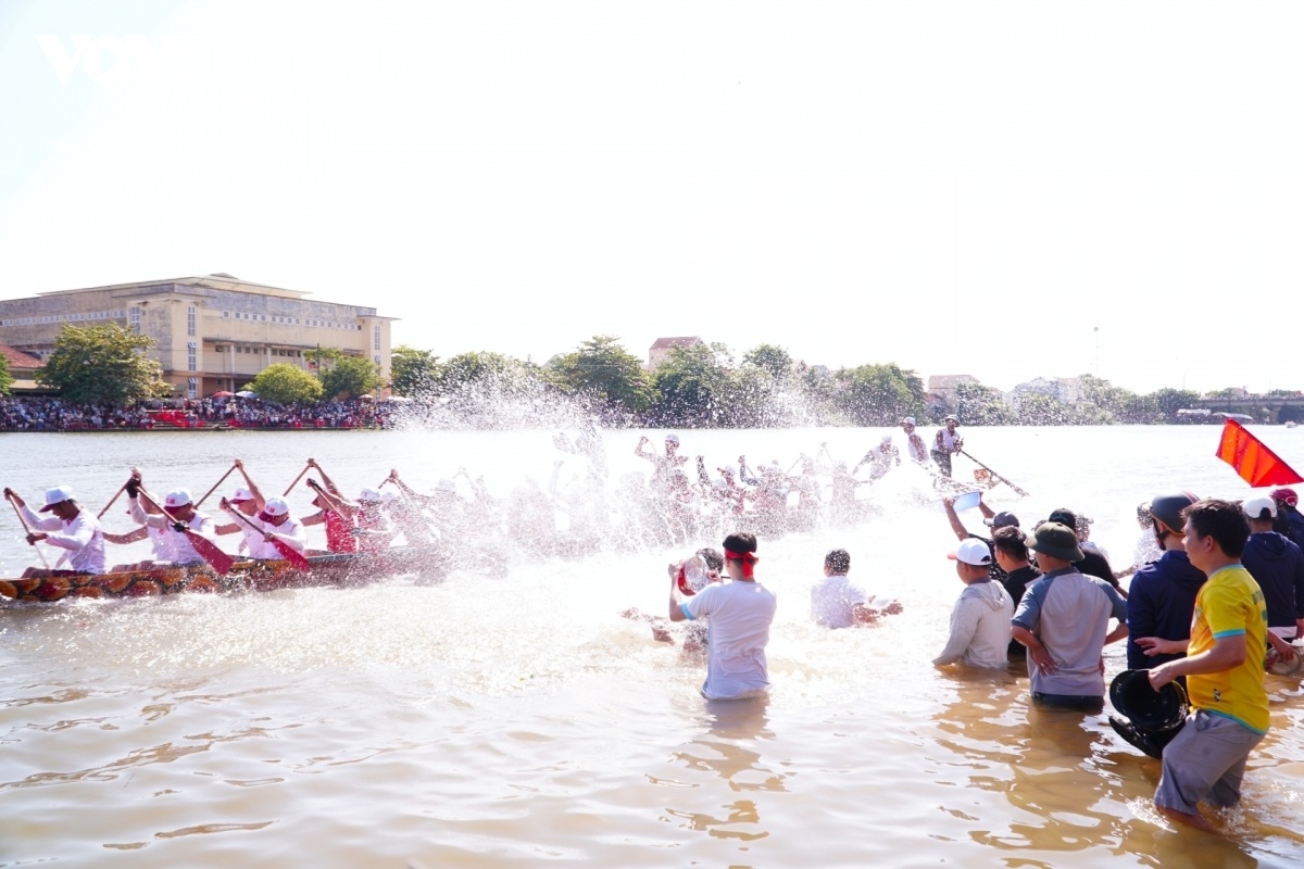 Người dân lao ra mép sông khoát nước cổ vũ cho các đội đua