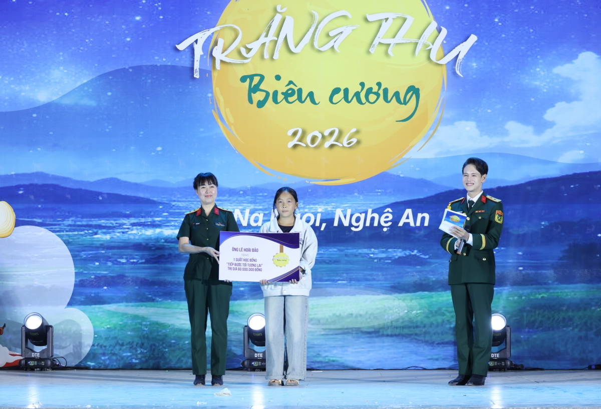 Trung tá Trần Lan- Trưởng phòng Truyền thông - Tổ chức sự kiện, Trung tâm Phát thanh - Truyền hình Quân đội thay mặt nhà hảo tâm trao học bổng cho em Già Y Nhìa (Ảnh: Phan Giang)