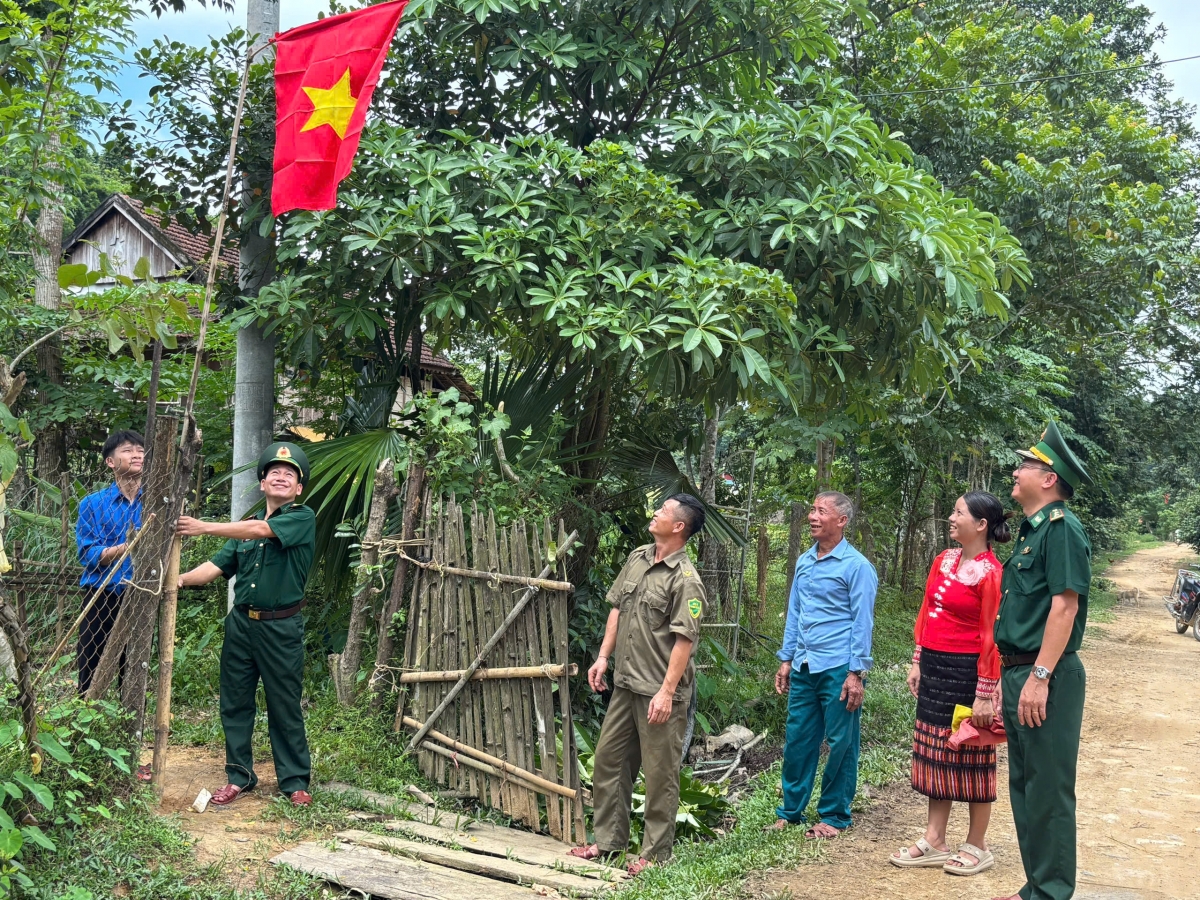 Ông La Văn Hồng (áo sơ mi xanh) cùng BĐBP và các lực lượng ở thôn bản đến từng nhà vận động các hộ dân treo cờ Tổ quốc trong ngày Quốc khánh (Ảnh: CTV Thiên Bình)