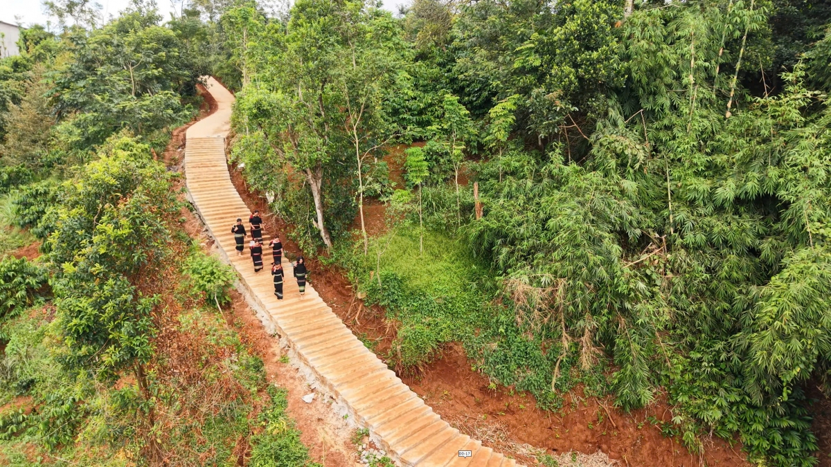 Con đường dẫn xuống bến nước buôn Hô đã được bê tông hóa, giúp người dân đi lại, gùi nước thuận tiện hơn. Không gian bến nước được chỉnh trang nhưng vẫn gắn với sinh hoạt thường ngày của bà con. (Ảnh: Hxiu)