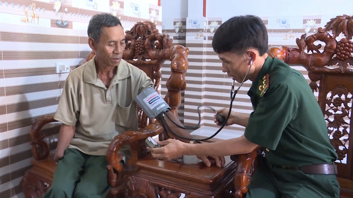Bộ đội biên phòng khám bệnh cho thương binh 4/4 Rơ Chăm Nich, ở thôn Moóc Đen, xã Ia Dom (Ảnh: Hoàng Qui)