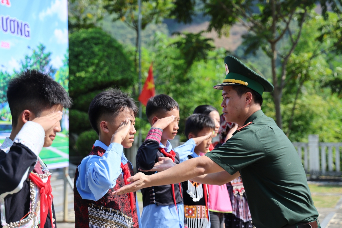 Thầy giáo biên phòng ân cần chỉnh sửa tư thế chào theo đúng chuẩn quân đội. Sự nghiêm túc, kỷ luật là yêu cầu quan trọng trong mỗi tiết học biên cương.(Ảnh: An Kiên)