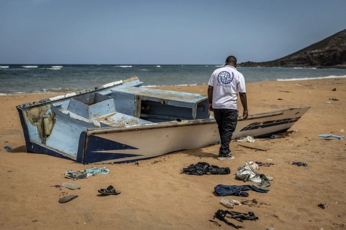 Một nhân viên IOM xem xét phần còn lại của một con thuyền chở người di cư ở Djibouti bị đánh đắm và trôi dạt vào bờ hồi tháng 4-2026 - Ảnh minh họa: AFP