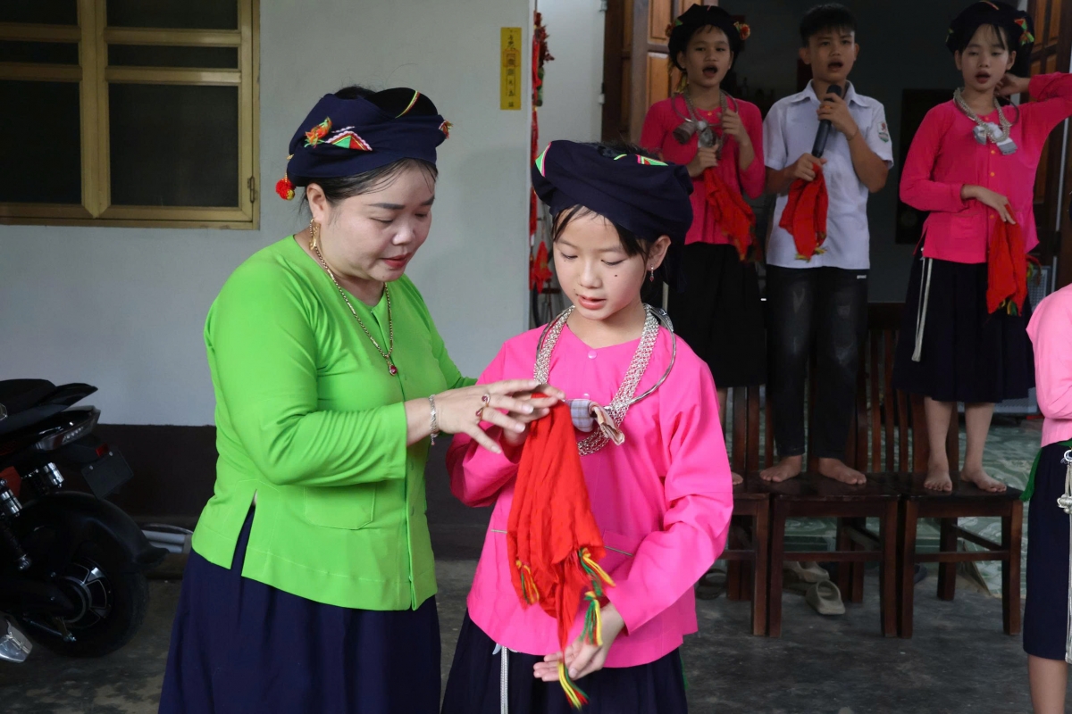 Chị Chắn chỉ bảo từng động tác, cách hát để các cháu tiếp thu tốt nhất (Ảnh: Đinh Tuấn)
