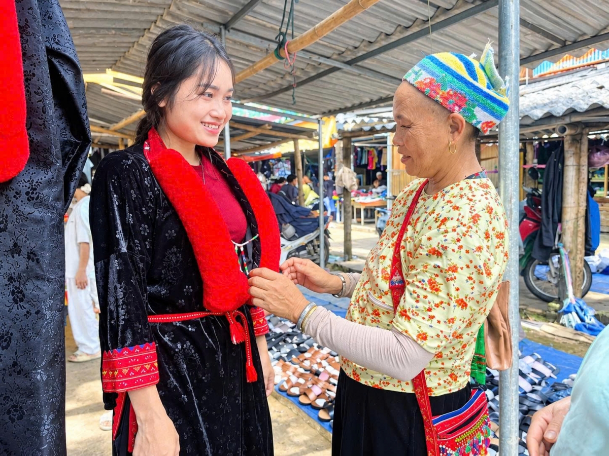 Chị Hoàng Mùi Kiều (bên trái) tự hào diện trang phục truyền thống của dân tộc Dao khi xuống chợ. (Ảnh: Công Luận)