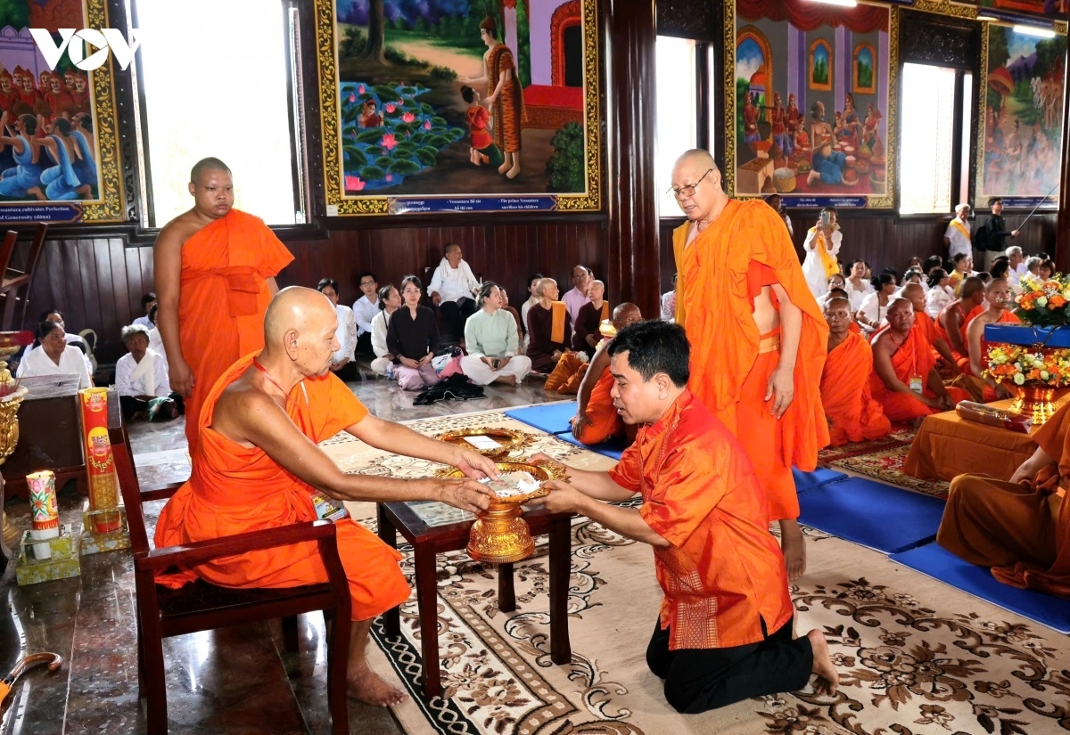 Phật tử thành kính dâng y cà sa và các vật dụng thiết yếu đến chư Tăng, thể hiện tinh thần hộ trì Tam bảo, lòng thành kính đối với người tu hành. (Ảnh: Hồng Phương)