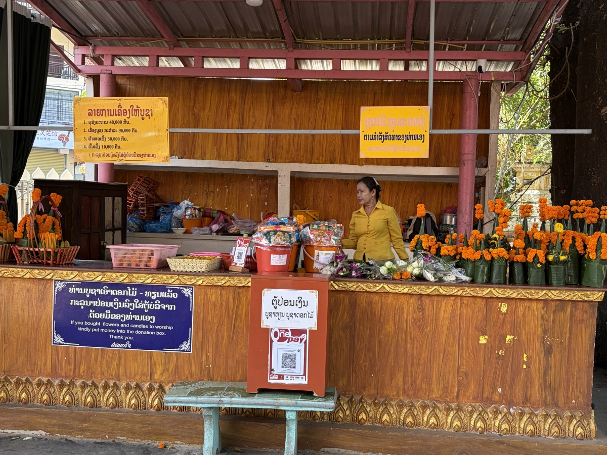 Đồ lễ được bày bán trước cổng chùa để phục vụ người dân sắm sửa lễ vật cho nghi thức "Tắt bạt". Ảnh: Trần Tuấn/VOV-Vientiane